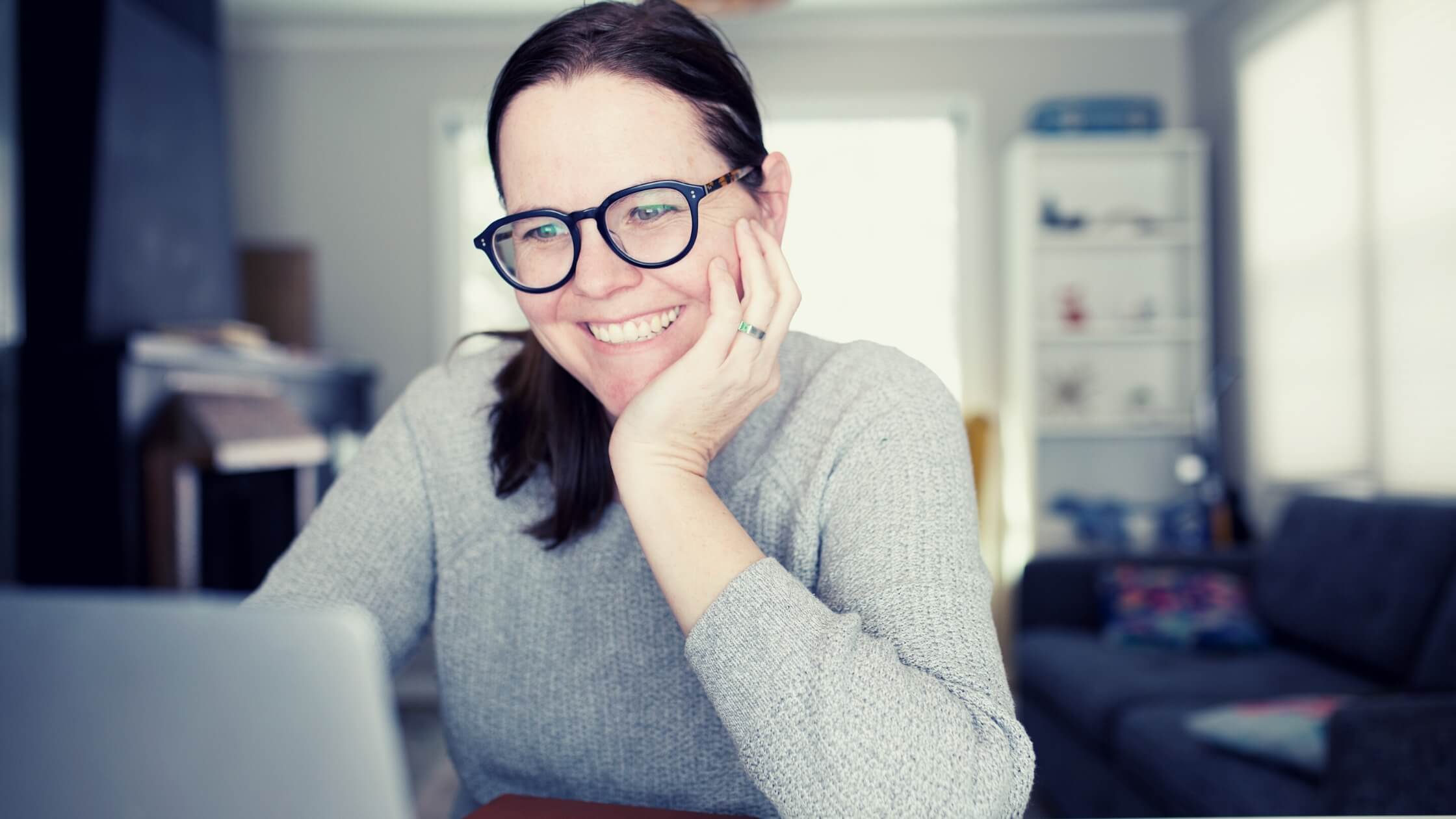 woman smiling in front of her computer