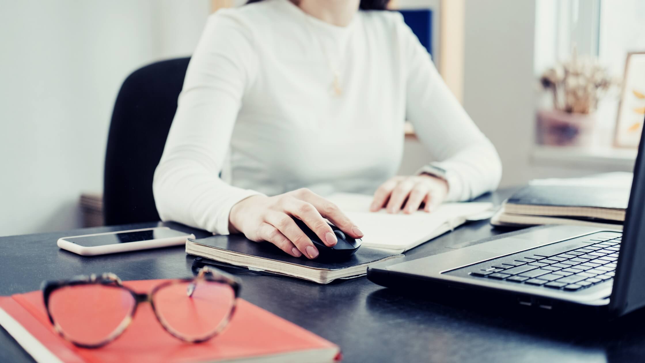 A woman works on her laptop while she's doing client accounting